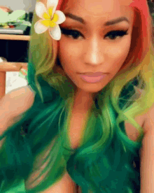 a woman with green hair and a flower in her hair takes a selfie