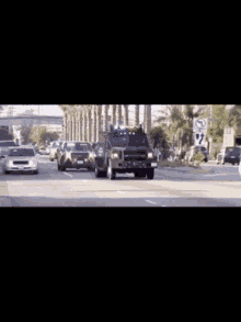 a row of police cars are driving down a street in front of a sign that says no parking
