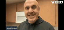 a man is smiling in front of a sign that says halal hogan on it
