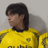 a man wearing a yellow jersey with the word ubia on it