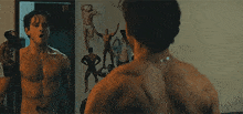 a shirtless man is standing in front of a mirror looking at himself .