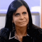 a woman with long black hair is making a funny face while looking at the camera .