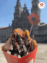a box of churros with a heart on a stick in front of a castle