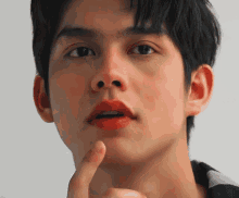a close up of a person 's face with their finger on their chin