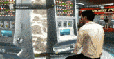 a man sits in front of a slot machine that says test drive on the screen