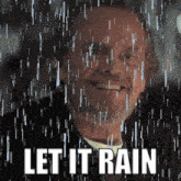 a man is smiling in the rain with the words let it rain