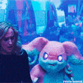 a woman standing next to a stuffed animal with purple eyes and the words fayth-avaxie below it