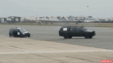 a blue car is being towed by a black van with the word thinki jules on the bottom right