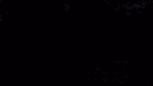 a close up of a person 's eyes in the dark with a purple background .