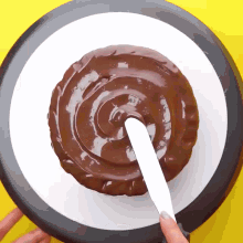 a chocolate cake is being spread with a spatula