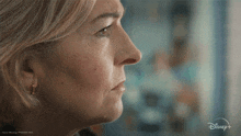 a close up of a woman 's face with a disney+ logo in the corner