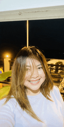 a woman with braces on her teeth smiles for a selfie