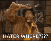 a man in a fur coat is making a funny face and says " hater where ?? "