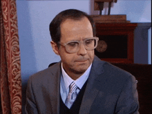 a man in a suit and tie with glasses on