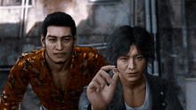 two men are standing next to each other and one is holding a small object in his hand