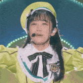 a girl wearing a yellow hat with a microphone on it