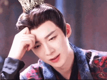 a man wearing a crown on his head looks down