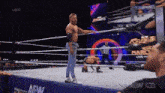 a wrestler is standing in the middle of a wrestling ring with a new dynamite logo on the screen behind him