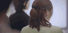 a woman with her hair in a ponytail is standing next to a man in a suit .