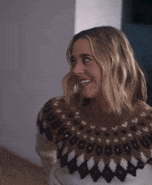 a woman wearing a sweater that has a pattern on it