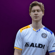 a man wearing a white shirt that says aldi