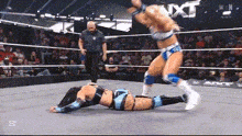 a woman is wrestling another woman in a wrestling ring .