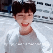 a young man in a white shirt is smiling with his mouth open