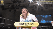 a female wrestler named mayu iwatani is standing in a wrestling ring