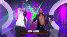 two men are dancing on a stage in front of a sign that says dark order .