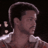 a man with a beard wearing a plaid shirt looks to the side