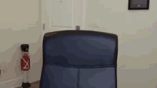 a blue office chair is sitting in front of a door with a nutcracker in the background .