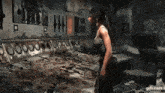 a woman is standing in front of a wall with a bunch of weapons on it .