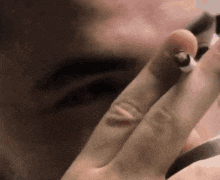 a close up of a person 's hand holding a cigarette