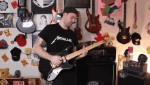 a man wearing a metallic shirt plays a guitar