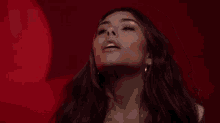 a woman is standing in front of a red background