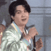 a close up of a person holding a microphone and singing .