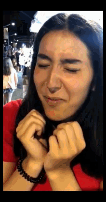 a woman in a red shirt making a funny face