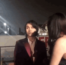 a man in a suit talks to a woman in a black dress .