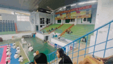 a group of people are practicing martial arts in a gym with a sign on the wall that says olympics