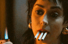 a woman has three cigarettes in her mouth