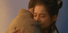 a man and a woman are hugging each other . the woman is crying and the man is holding her .