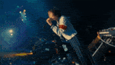 a woman singing into a microphone with a red and white armband that says ' a ' on it