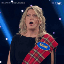 a woman wearing a kilt and a name tag that says nadine