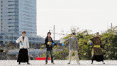 a group of men are standing in front of a building holding frisbees in their hands