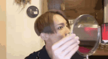 a man is looking at himself in a small mirror .