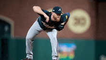 a baseball player with the letter a on his hat is pitching the ball