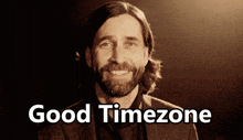 a man with a beard is smiling with the words good timezone above him