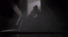 a person walking down stairs in a dark room