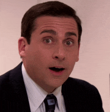 a man in a suit and tie is making a funny face