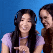 a woman wearing headphones is smiling while sitting next to another woman .